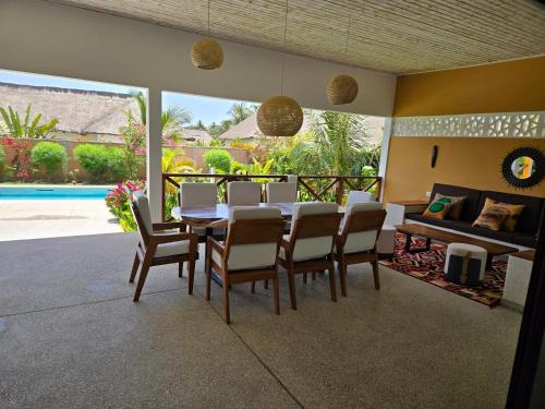 a dining room with a table and chairs at Villa d'évasion proche de la plage in Boukot Ouolof