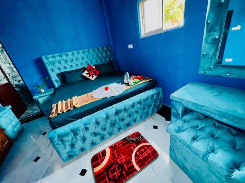 a blue room with a bed and a couch at White Palace airport hotel in Katunayake