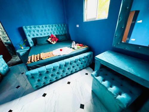 a blue room with a couch in the corner at White Palace airport hotel in Katunayake