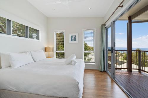 En eller flere senge i et værelse på Bombora 5 Bedroom by Discover Stradbroke