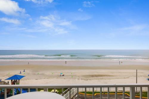 a view of a beach with people on the sand at Direct Oceanfront 1BR Balcony King Bed Beach Access in Daytona Beach