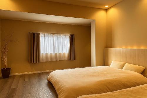 a bedroom with a large bed and a window at 滋庵 jian okayama in Okayama