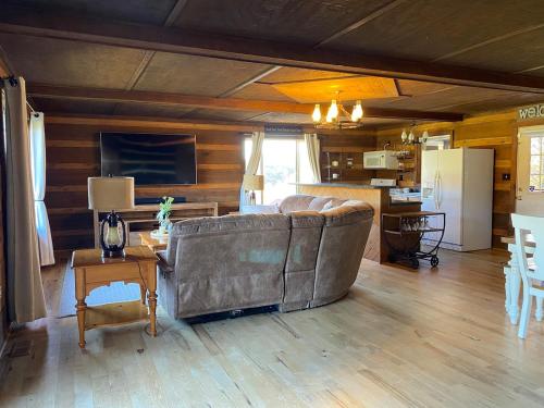 a living room with a couch and a kitchen at Red Roof Cabin - Suite 