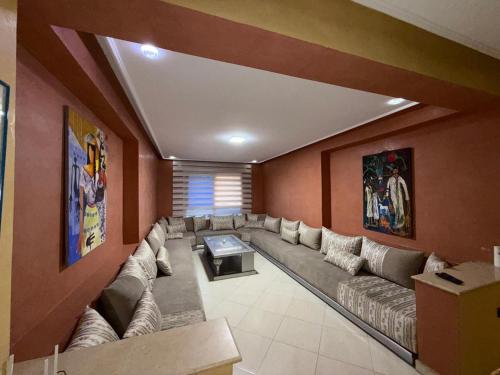 una sala de estar con un sofá grande en una habitación en Appartement Jihan, en Tánger