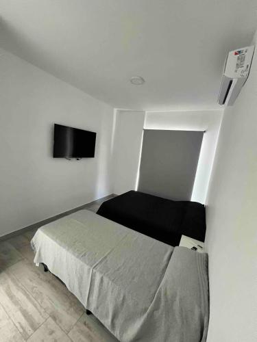 a bedroom with a bed and a flat screen tv at Torres Al Mar in Monte Hermoso