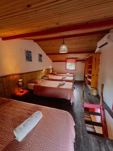 a bedroom with two beds in a room at Casa Vulva Caraíva l Hostel feminino com vibe de lar in Caraíva