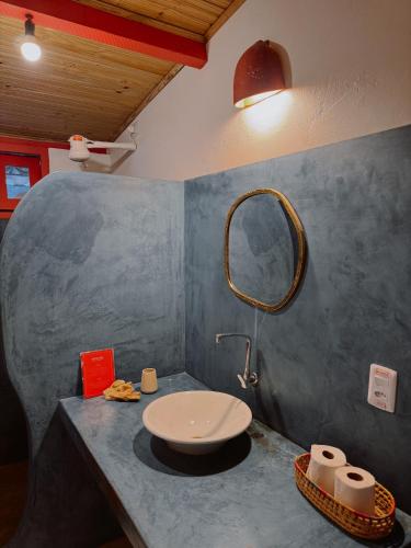 a bathroom with a sink and a mirror on a counter at Casa Vulva Caraíva l Hostel feminino com vibe de lar in Caraíva