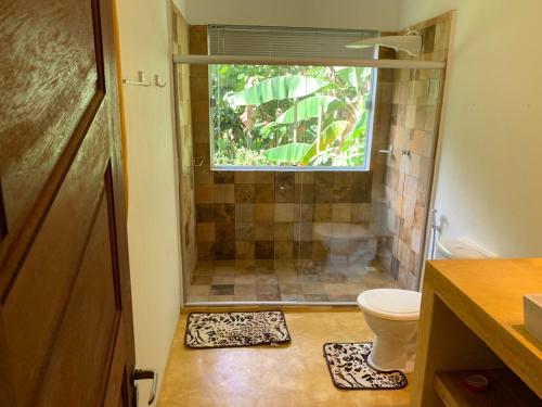 een badkamer met douche, toilet en raam bij Casa Baleia in Itacaré