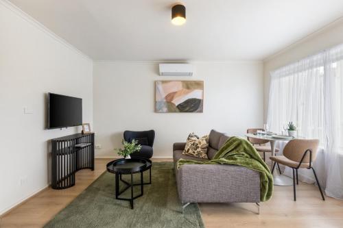 a living room with a couch and a table at Newly Renovated Geelong Serviced Apartments by Short & Long Stays in Geelong
