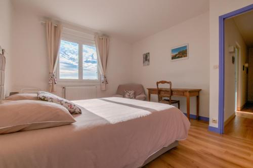 Un dormitorio con una gran cama blanca y una ventana en Chez Lucie en Touraine, en Montlouis-sur-Loire
