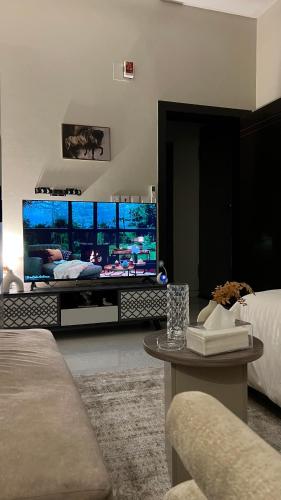 a living room with a large flat screen tv at استديو هادئ وأنيق بتصميم عصري in Al Kharj