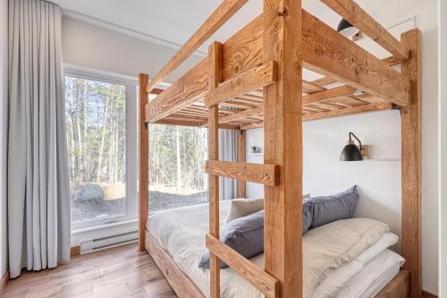 a bedroom with a bunk bed with a window at Slow Living Lodge- SPA - Pet friendly in Saint Come
