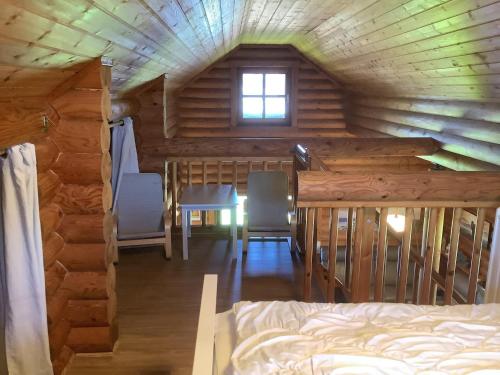 een slaapkamer in een blokhut met een bed en stoelen bij Blockhaus in Burhave in Hoddersdeich