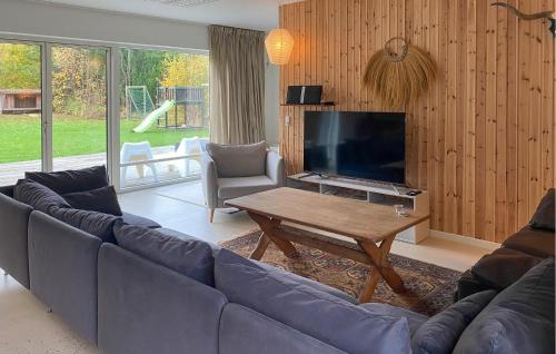 a living room with a blue couch and a tv at Beautiful Home In Sjællands Odde in Yderby
