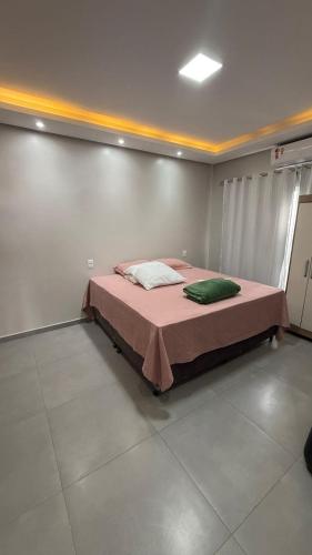 a bedroom with a bed with a pink blanket at Casa Pé no Sal in Salinópolis
