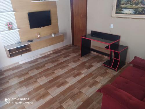 Cianorteにあるcasa aconchegante para seu descansoのリビングルーム(デスク、テレビ付)