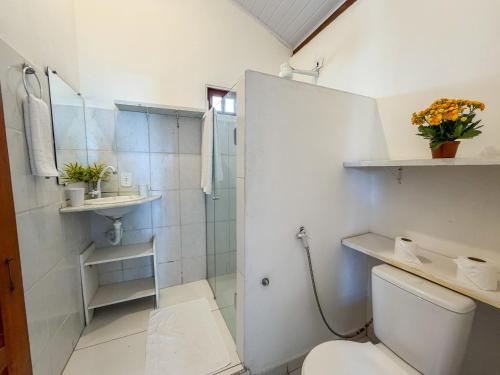 a white bathroom with a toilet and a shower at Pousada João Maria in Trancoso