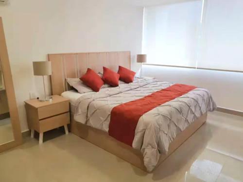 a bedroom with a large bed with red pillows at 16 Loft Espectacular - Aire Acondicionado, Consulado in Guadalajara