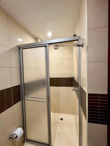 a shower stall with a glass door in a bathroom at Hotel Plaza Mayor 44 in Medellín