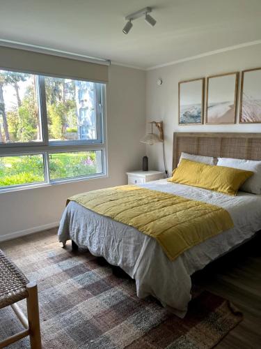 a bedroom with a large bed and two windows at 1st floor apartment - Lomas Puyai - Beach 15 min in Papudo