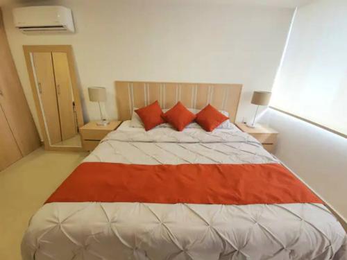 a bedroom with a large bed with red pillows at 16 Loft Espectacular - Aire Acondicionado, Consulado in Guadalajara