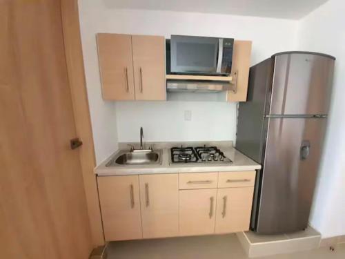 a small kitchen with a sink and a refrigerator at 16 Loft Espectacular - Aire Acondicionado, Consulado in Guadalajara