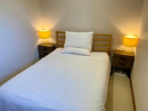 a bedroom with a bed with two lamps on both sides at Hillside Retreat With Pool in Flagstaff Hill