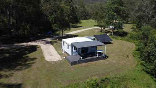 una vista aerea di una piccola casa con pannelli solari di The Burrows Off Grid Cabin, Unplug, Relax & Unwind a Wollombi