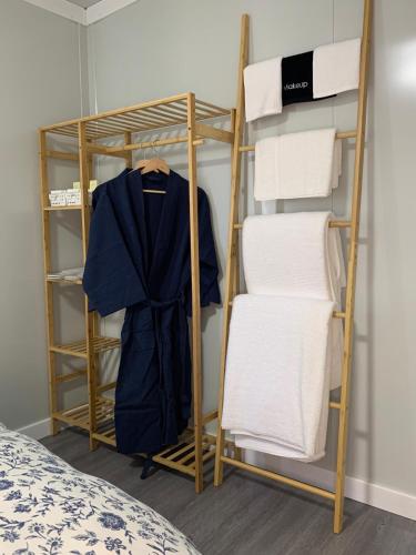 a room with a rack with a robe and towels at The Burrows Off Grid Cabin, Unplug, Relax & Unwind in Wollombi