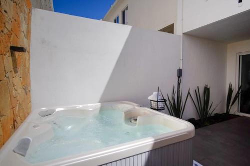 une baignoire jacuzzi dans une salle de bain aux murs blancs dans l'établissement Modern House with Jacuzzi & Grill 3BR, à La Playita