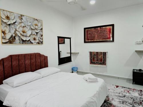 a bedroom with a white bed and a mirror at Homestay BAYT AL - JAZMY in Kuantan