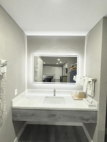 a bathroom with a large white sink and a mirror at Super 8 by Wyndham Visalia in Visalia
