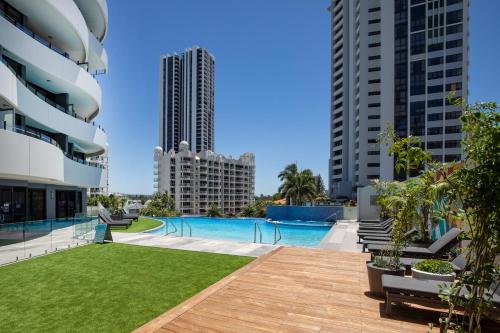 a swimming pool in the middle of two tall buildings at The Wave Resort in Gold Coast