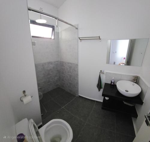 a bathroom with a toilet and a sink at Cozy nest in Tatu City