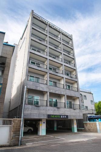 a tall white building with a parking lot at Yolowa Hotel in Chumunjin