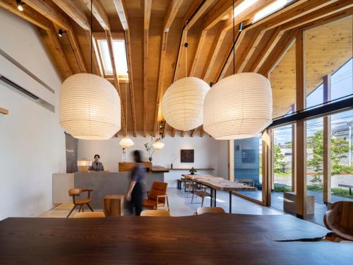 a dining room with a table and chandeliers at 富士山リトリートMUKUten舎 富士宮 MtFuji Retreat MUKUtensha Fujinomiya natural wood retreat hotel in Fujinomiya