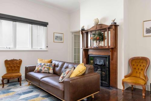 a living room with a couch and a fireplace at The Golden Key Henley Beach in Henley Beach South