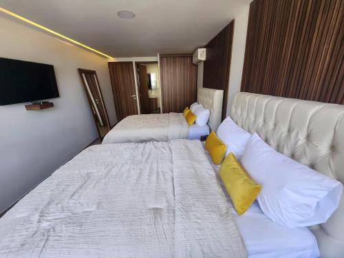 a hotel room with two beds and a flat screen tv at 21 Bella habitación Consulado in Guadalajara