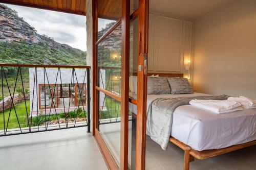 a bedroom with a bed and a balcony at Apartamento Luxuoso com Vista para as Montanhas in Mucugê