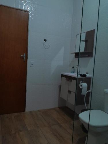 a bathroom with a toilet and a glass shower at Chácara pedacinho do paraíso in Cesário Lange