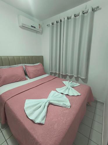 a bedroom with a bed with two white towels on it at Ap confortável e Aconchegante in Petrolina