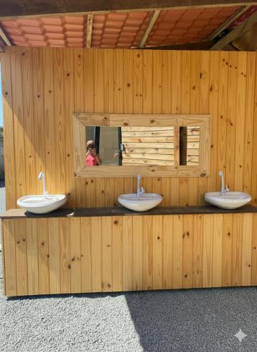 a bathroom with three sinks in a wooden building at Cabanas Beach Maresias in São Sebastião