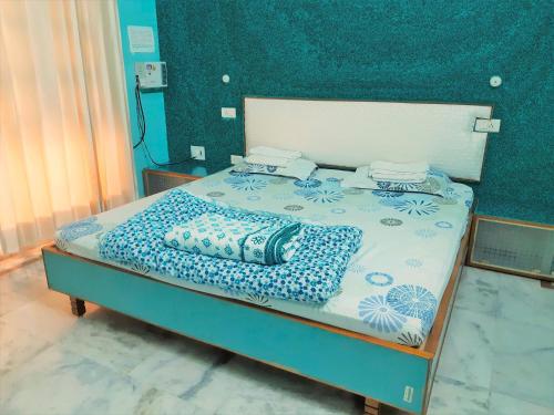 een bed met blauwe en witte lakens en kussens erop bij Homestay - Serviced Apartment "ISH Atithya" with Modular Kitchen, various amenities and Complimentary Breakfast in Lucknow, IN in Lucknow