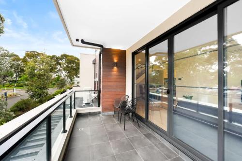 ein Balkon mit Glastüren und Blick auf eine Straße in der Unterkunft Amazing Modern Townhouse at Heart of Mount Waverley in Mount Waverley