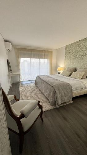 - une grande chambre avec un grand lit et une chaise dans l'établissement Réveillon 2026 CASA LOS PADEL - Vitorino dos Piães, à Navio