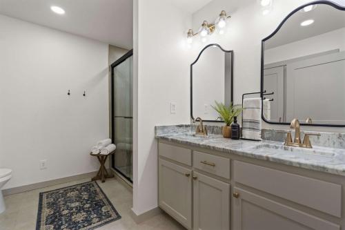 Un baño con dos lavabos y un espejo grande. en Group Ready! 3BR Home Near WinStar, en Thackerville