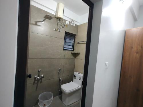 a small bathroom with a toilet and a window at ElShium Homes in Cochin