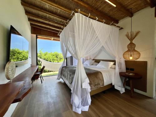un dormitorio con una cama con dosel en Umbelina Pousada Boutique, en Porto de Galinhas