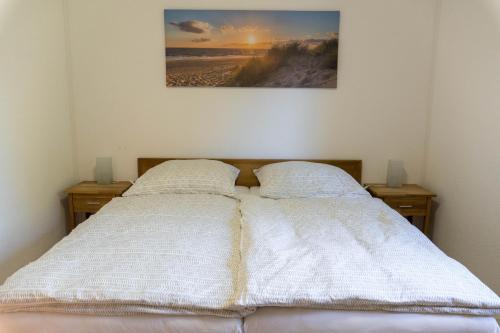 a bedroom with two beds and a picture of a beach at Aurora Lodge in Frielendorf