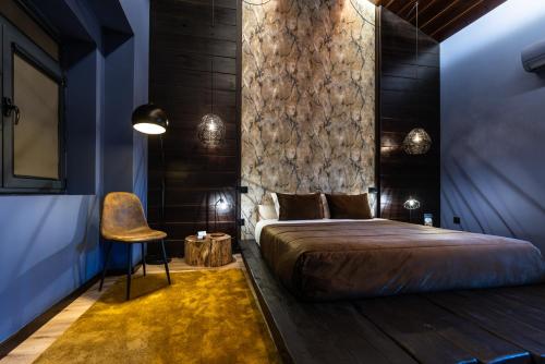 a bedroom with a large bed and a chair at ZEN & ART - Alojamento de Charme in Santa Maria Da Feira